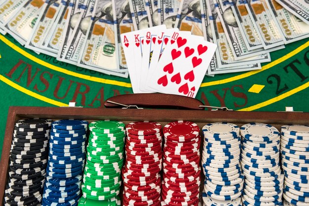 Pokerchips in de koffer op een speeltafel met kaarten en dollars