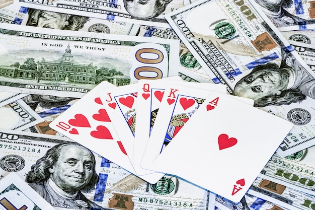Pokercombinaties van kaarten op de achtergrond van dollarbiljetten