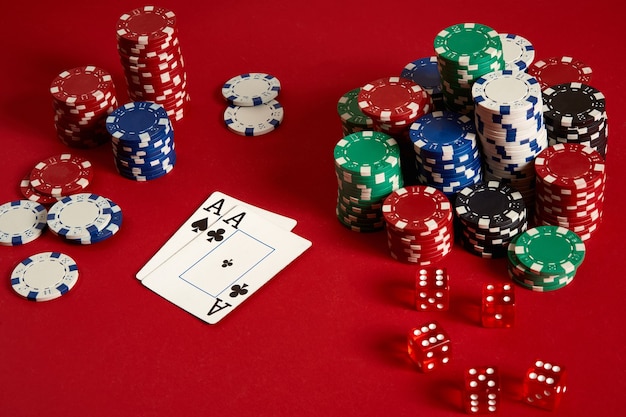 Pokerfiches en azen op rode achtergrond. Groep verschillende pokerfiches. Casinoachtergrond. Ruimte kopiëren. Stilleven. Een paar