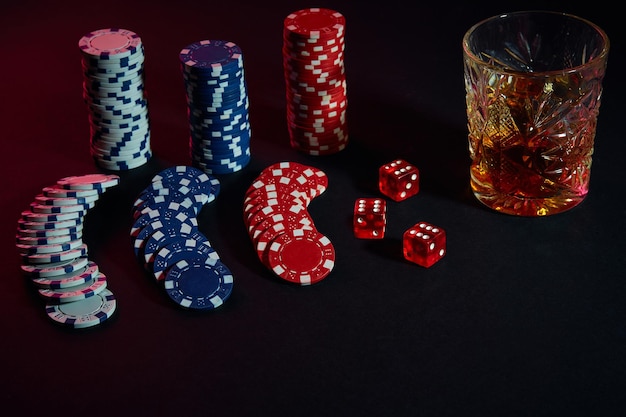 Pokerfiches en wijnglas cognac op donkere tafel. Stilleven. Het concept van gokken. Online pokeren