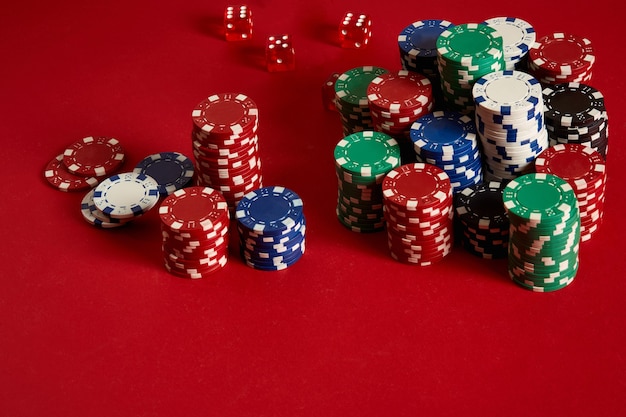 Pokerfiches op rode achtergrond. Groep verschillende pokerfiches. Casinoachtergrond. Ruimte kopiëren. Stilleven