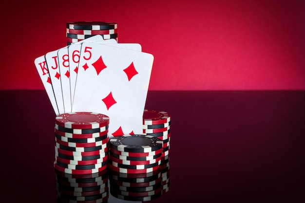 Pokerkaarten met flush combinatie. Close-up van speelkaarten en chips in pokerclub. Gratis advertentieruimte