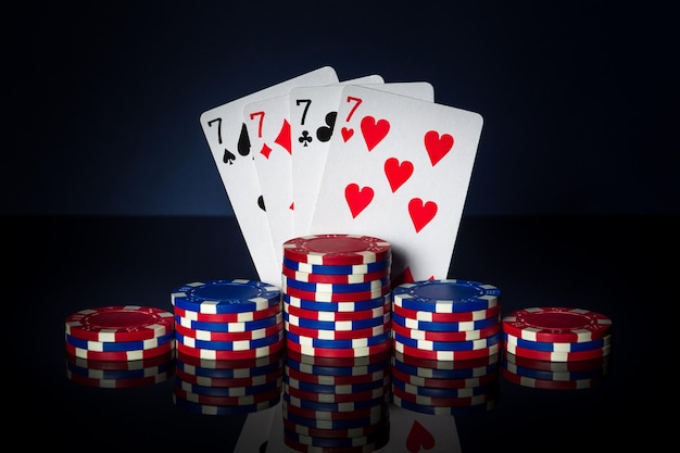 Pokerspel met four of a kind of quads-combinatie Chips en kaarten op donkere tafel