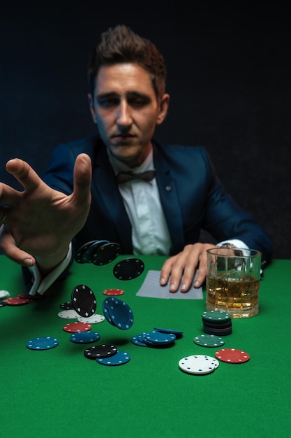 Pokerspeler gooit chips op groene tafel in casino