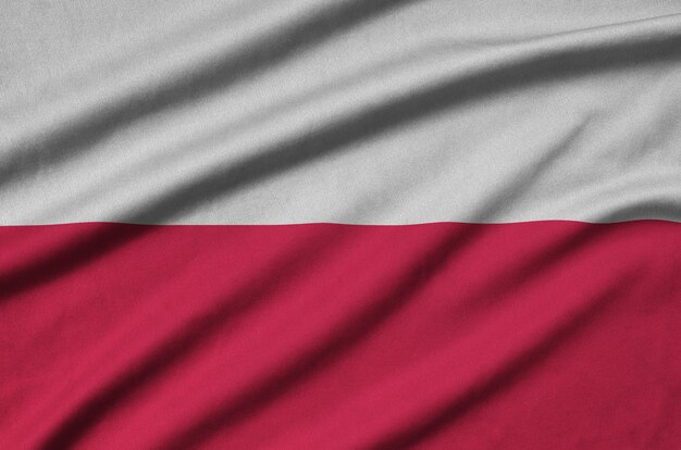 Poland flag  is depicted on a sports cloth fabric with many folds.