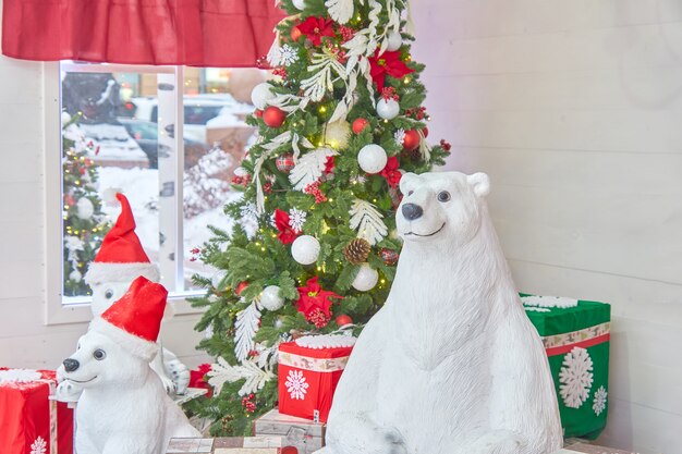 ボールと弓とギフトで飾られたクリスマスツリーとホッキョクグマ。クリスマスの部屋のインテリア。