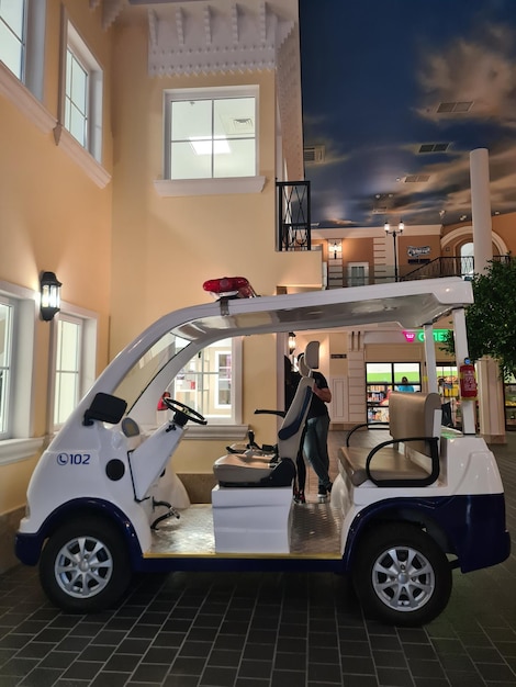 A police car is parked in a mall with a large window behind it.