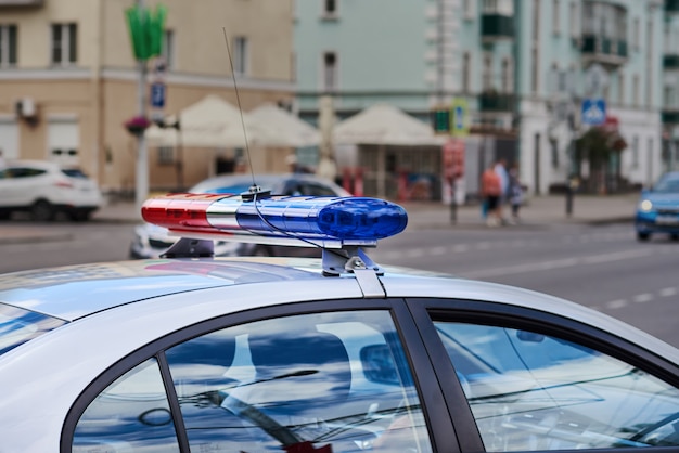 Police car lightbar closeup against city street