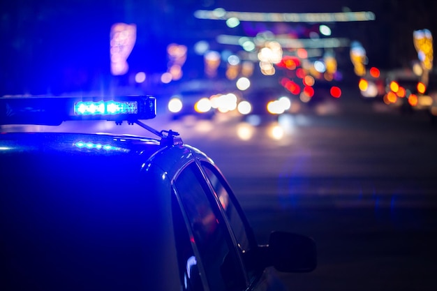 Photo police car lights at night in city with selective focus and bokeh