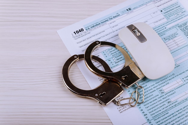 Police handcuffs lie on the tax form 1040