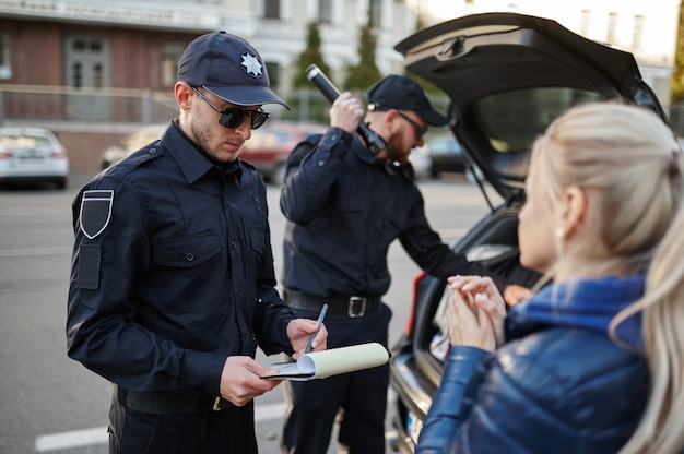 Полицейский патруль останавливает женщину и проверяет машину