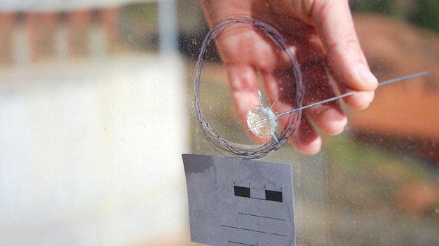 A police scientist specialist is measuring angles in a window pane shot