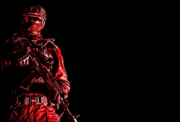 Photo 警察の特殊部隊、迅速な対応チームの役員、黒い制服を着た戦術的なグループファイター、ヘルメットとマスクのアイデンティティの後ろに隠された、アサルトライフルで武装した、黒い背景での控えめなスタジオ撮影