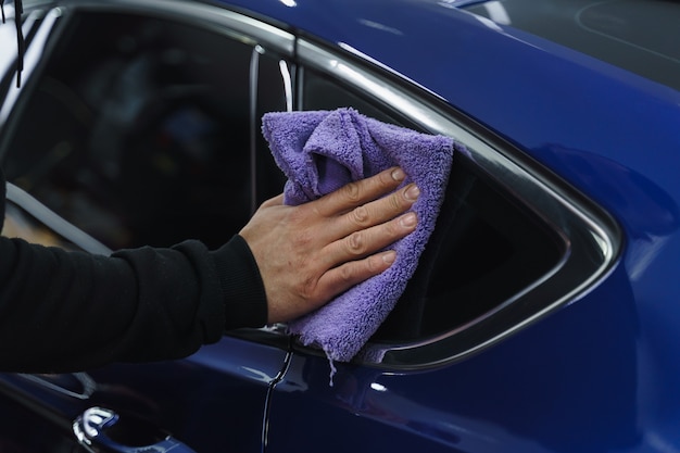 Foto polijsten auto na het schilderen. detaillering van de auto van buitenaf. apparaat voor polijsten in handen