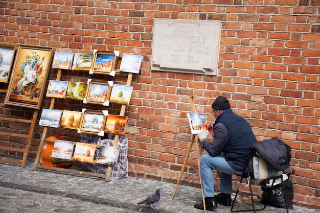 Polish man drawing painting watercolor image picture for show and sale pole people and foreign travelers at Warsaw Barbican or Barbakan Warszawski at Warszawa on September 21 2019 in Warsaw Poland