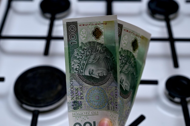 Polish money zloty in hand on the background of a gas stove