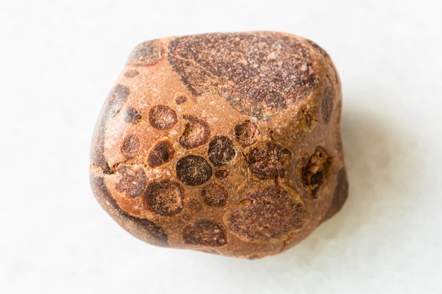 Polished Bauxite rock on white marble