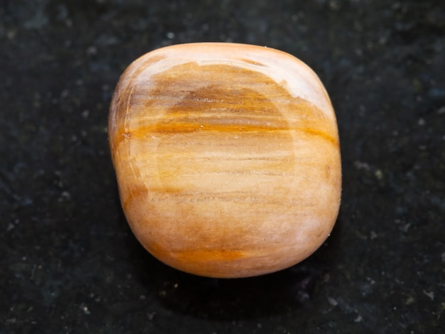 Polished brown tiger's eye gem on dark background