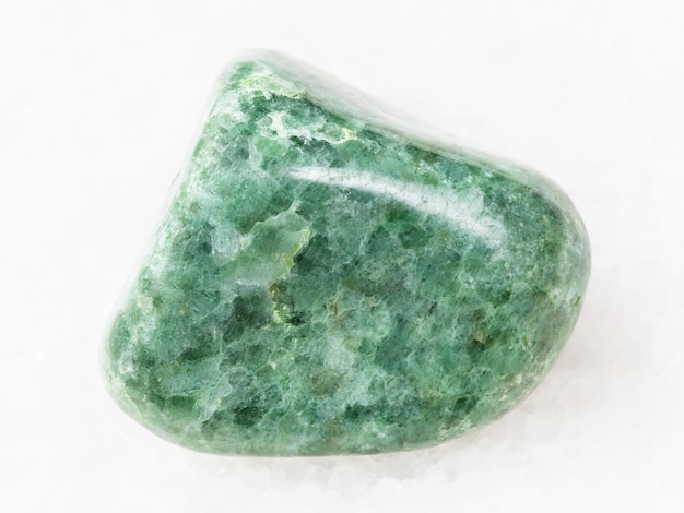 Polished green Jadeite gemstone on white