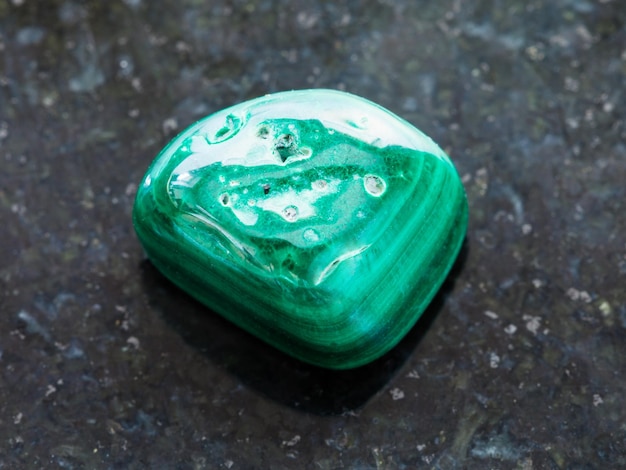 Polished Malachite gemstone on dark