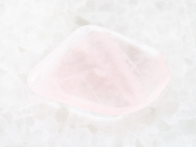 Polished pink quartz gem stone on white