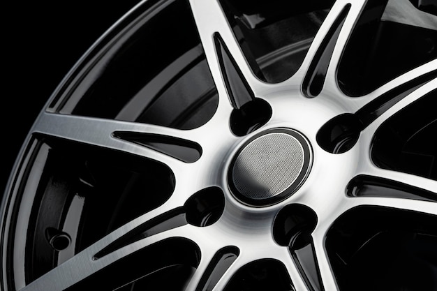 Photo polished spokes of a car alloy wheel, close-up on a black background.