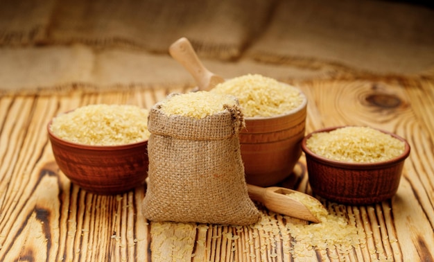 Polished steamed rice in bowls and bags on a wooden background High quality photo