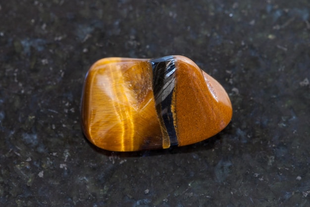 Polished tiger eye gemstone on dark background