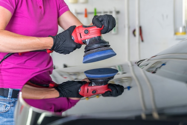 polishing the car body with a mechanical brush