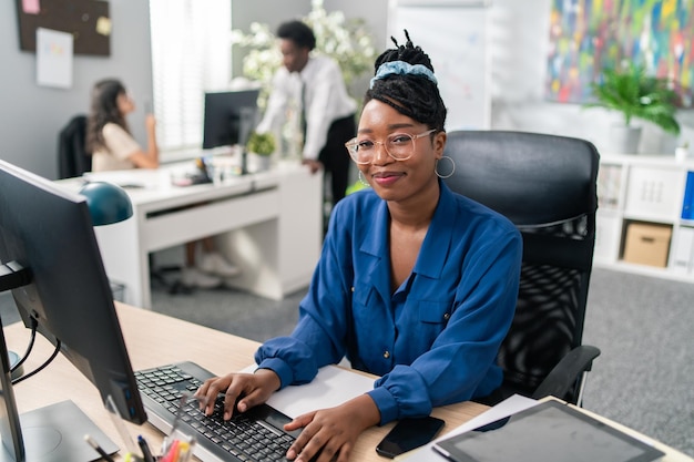 Polite elegant customer service representative in large corporation sits at computer