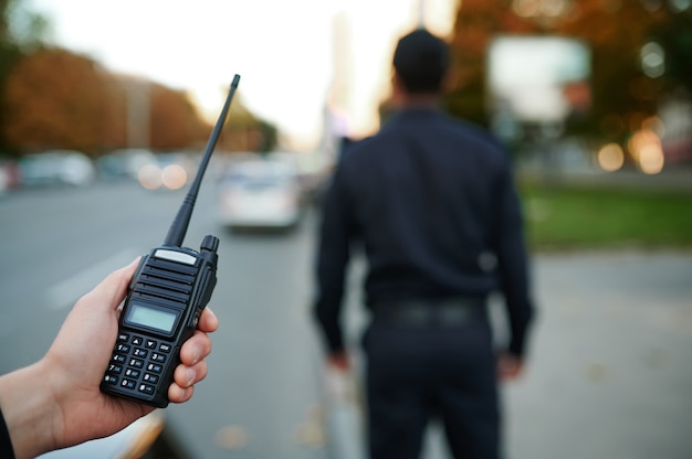 Politieagent heeft een walkietalkie in zijn hand