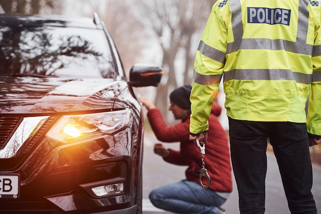 Politieagent in groen uniform betrapt autodiefstal op de weg.