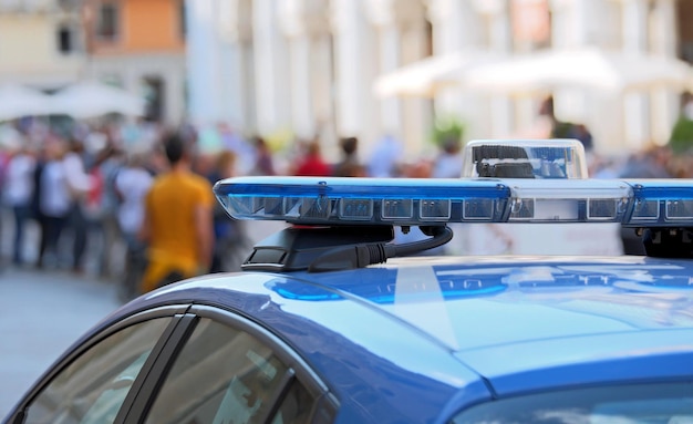 Foto politieauto met blauwe sirenes op het plein.