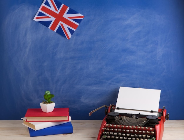 Politiek nieuws en onderwijsconcept rode schrijfmachinevlag van de boeken van het Verenigd Koninkrijk op tafel
