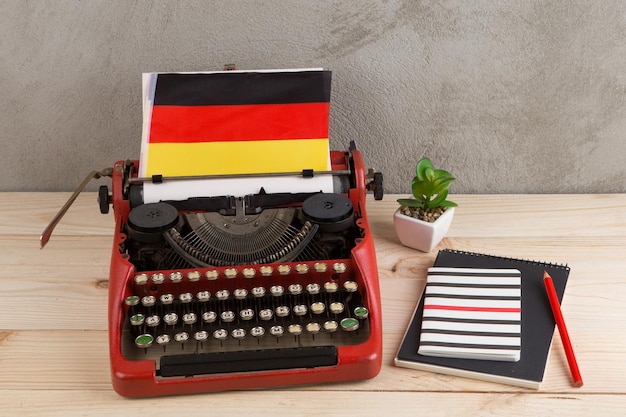 Politiek nieuws en onderwijsconcept rode schrijfmachinevlag van Duitsland en notitieboekjes