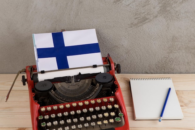 Politiek nieuws en onderwijsconcept rode schrijfmachinevlag van het notitieboekje van Finland