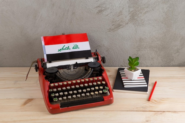 Politiek nieuws en onderwijsconcept rode vintage typemachinevlag van het Irak-potlood
