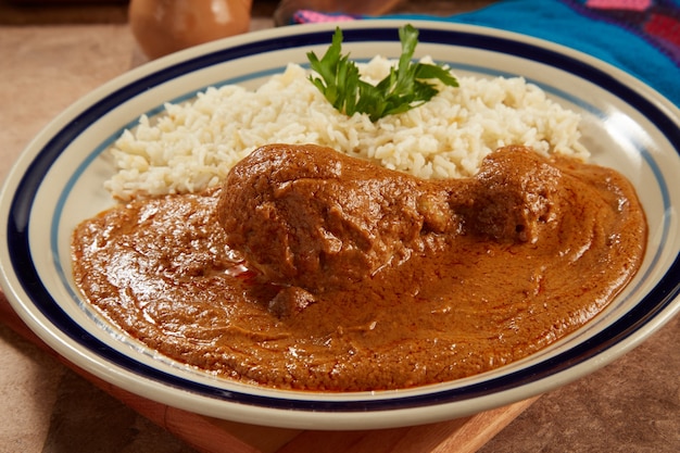 Pollo con pipiar rojo con arroz blanco comida mexicana