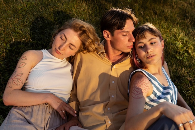 Photo polyamorous couple spending time together outdoors in the park