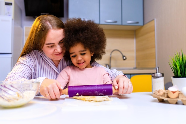 Polyethnic family cooking biscuits make breakfast at home together