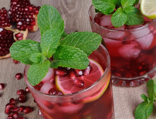 Pomegranate cocktail with slices of lime, mint and ice