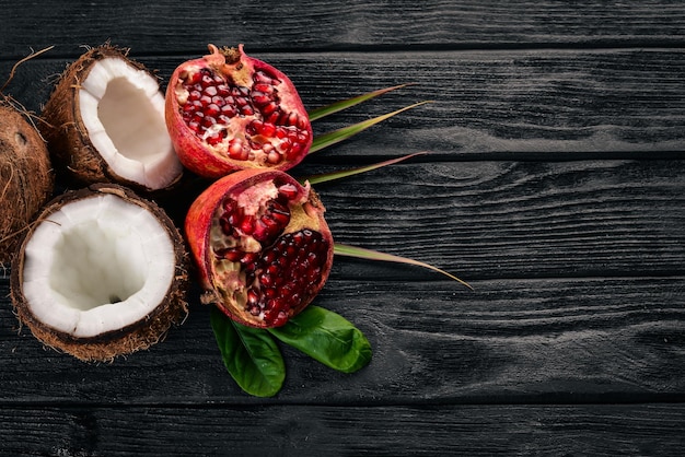 Pomegranate and coconut Fresh fruits On a wooden background Top view Free space for text