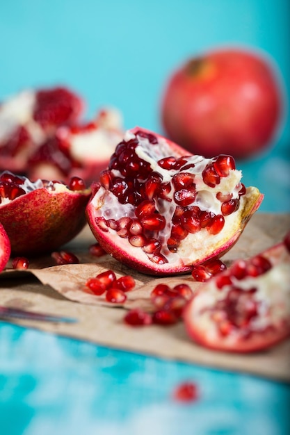 Photo pomegranate fruit on a cyan wooden surface. closeup