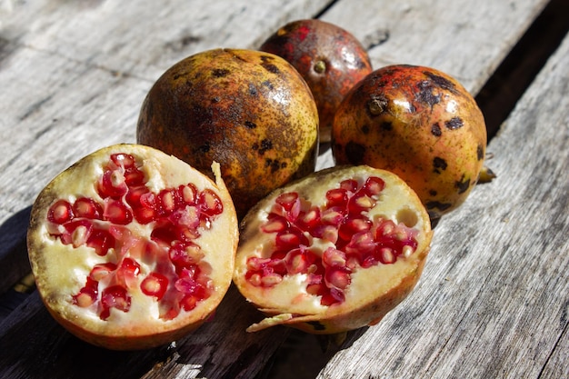 Foto il frutto del melograno punica granatum si apre per rivelare i grappoli di semi succosi all'interno