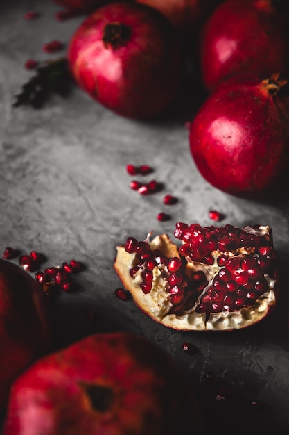 Photo pomegranate fruit. ripe and juicy pomegranate on rustic grey wall with copy space for your text.