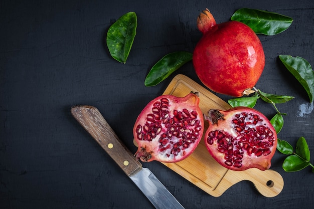 Pomegranate fruit sliced on a black background