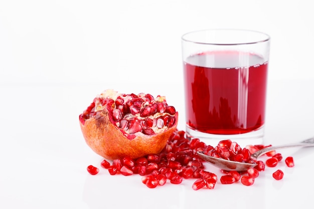 Pomegranate fruit with seeds. A glass of pomegranate juice