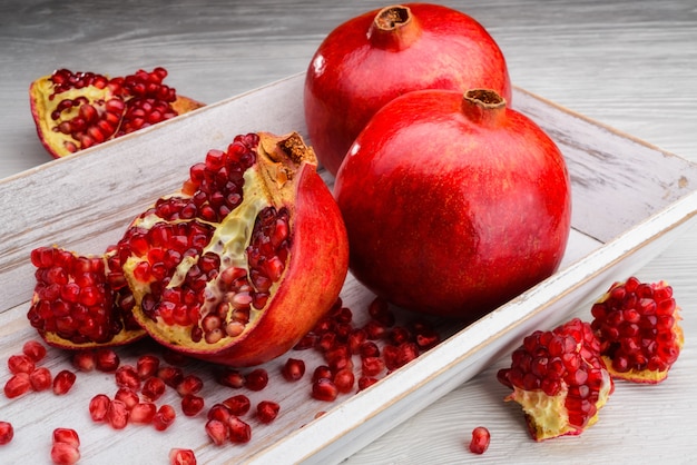 Pomegranate fruits on light wooden background