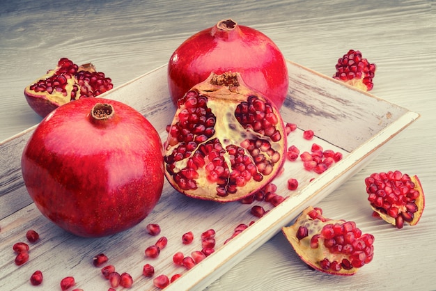 Pomegranate fruits on light wooden background