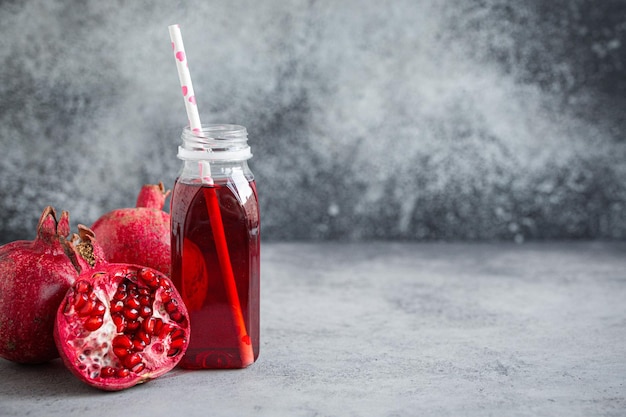 Pomegranate juice in bottle and fruit copy space